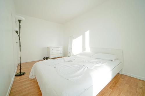 a white bedroom with a white bed and a lamp at Appartement familial - proche Paris in Alfortville