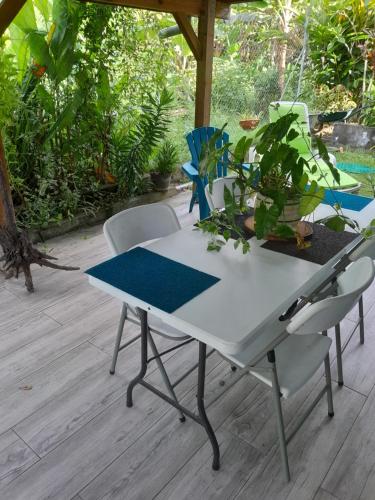Una mesa blanca y sillas en un patio. en les lau, en Sainte-Anne
