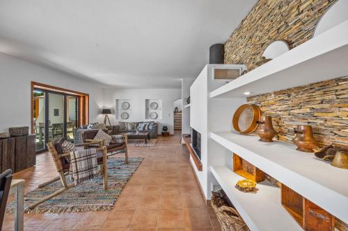 São DomingosTons da Terra - Casa de Campo & SPA的客厅设有壁炉和石墙