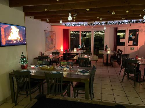 a restaurant with tables and chairs and christmas decorations at Camping & Chalets La Santoire in Saint-Bonnet-de-Condat