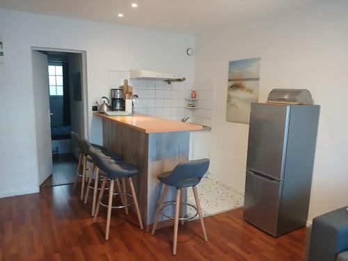 La cuisine est équipée d'un bar avec tabourets et d'un réfrigérateur. dans l'établissement Appartement, à Sexey-aux-Forges