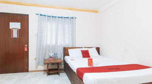 a bedroom with a bed and a window at RedDoorz Hostel at Megans Paradisio Beach Resort in Zambales