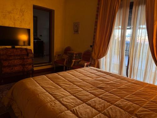 a bedroom with a large bed and a large window at Villa Elena in Montefiascone