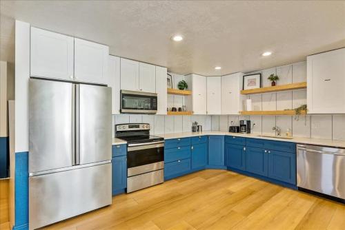 a kitchen with blue cabinets and a stainless steel refrigerator at Private Room & Bathroom Hiking Trails Close By in Ogden