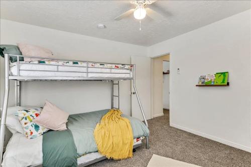 a bedroom with a bunk bed and a ceiling fan at 5 Mins off i15 Pickle Ball Courts Close By in Bountiful
