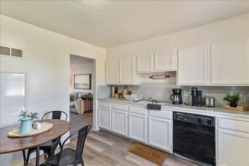 a kitchen with white cabinets and a table with chairs at Pickle Ball Courts Close By 5 Mins off i15 in Bountiful