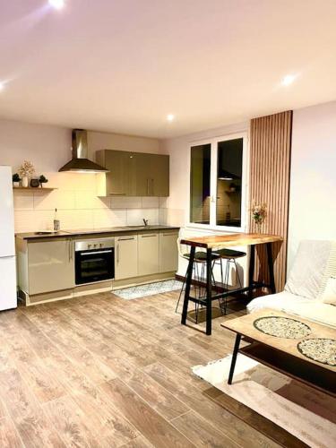 une cuisine et un salon avec un canapé et une table dans l'établissement Le Cosy, à Saint-Martin-Lalande