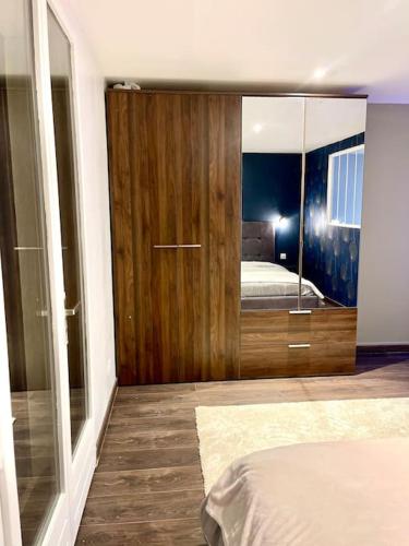 - une chambre dotée d'une porte en bois avec un lit et un miroir dans l'établissement Le Cosy, à Saint-Martin-Lalande