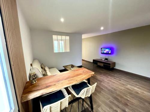 un salon avec un canapé, une table et une télévision dans l'établissement Le Cosy, à Saint-Martin-Lalande