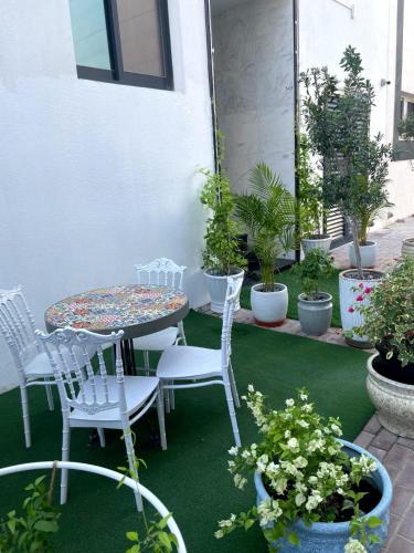 a patio with a table and chairs and potted plants at Ista Vacation Homes Rental LLC in Dubai