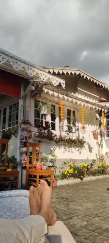 a person laying on a bed in front of a building at 11 Monteviot: Luxury homestay overlooking a tea estate in Kurseong