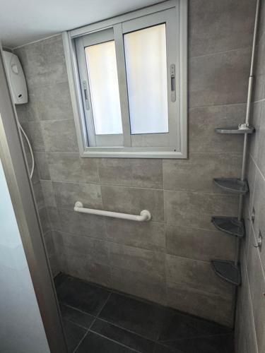 a bathroom with a shower with a window at Georges 2 Bedroom Apartment in Limassol