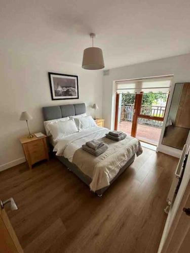 a bedroom with a large bed and a wooden floor at BTown 2 Bed 2 Bath in Ballybrack