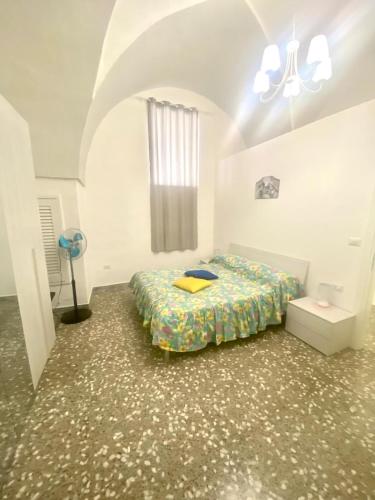 a bedroom with a bed in a white room at House Malù apartment in Tuglie