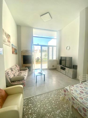 a living room with a couch and a tv at House Malù apartment in Tuglie