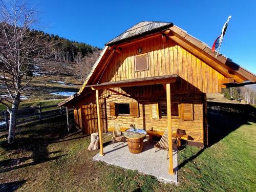 LučeにあるKoča Lipa pod Veliko planinoの小さな木造の小屋(庭にポーチ付)