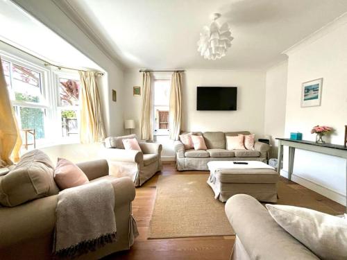 a large living room with couches and a tv at New Forest Cottage in Lyndhurst