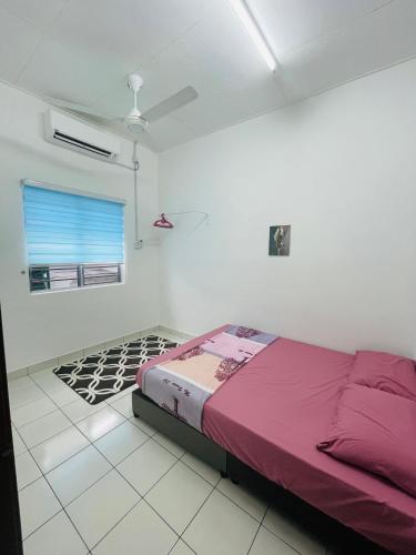 a bedroom with a bed in a white room at Al Ghazali Homestay in Seri Iskandar