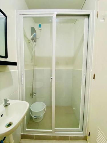 a bathroom with a shower with a toilet and a sink at Plumera Condo Near Airport Malls & Schools with Elevator in Lapu Lapu City