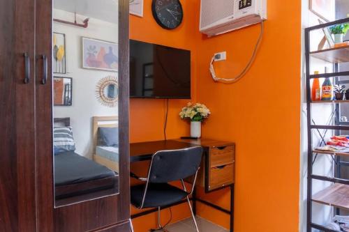 an orange room with a desk and a chair at Plumera Condo Near Airport Malls & Schools with Elevator in Lapu Lapu City