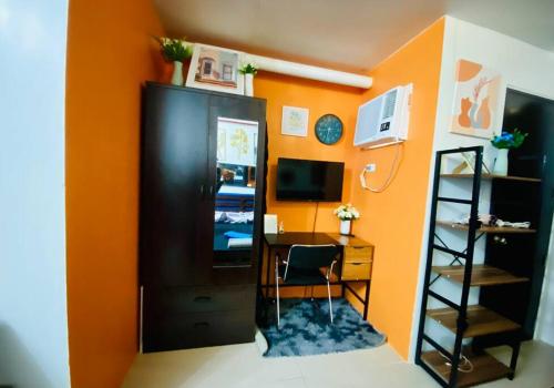 an orange room with a desk and a computer in it at Plumera Condo Near Airport Malls & Schools with Elevator in Lapu Lapu City