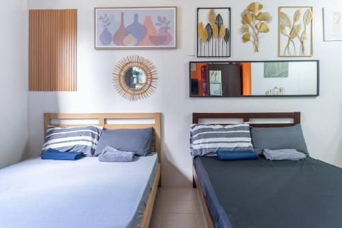 two beds sitting next to each other in a bedroom at Plumera Condo Near Airport Malls & Schools with Elevator in Lapu Lapu City
