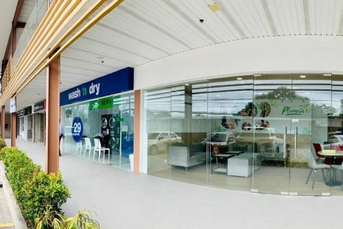 a mall with a car dealership with glass windows at Plumera Condo Near Airport Malls & Schools with Elevator in Lapu Lapu City