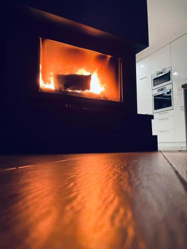 a living room with a fire in a fireplace at Żuławski Chillout in Stanisławowo