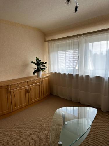a living room with a glass table and a window at Apartment 19 in Walkenried