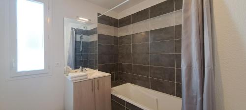 Un baño con bañera, lavabo y ducha. en T2 Charmant, spacieux parking privé tram et metro, en Toulouse