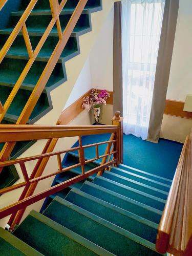 a staircase in a house with blue walls and wooden railings at Hotel Wesselényi in Győr