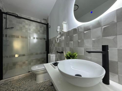 a white bathroom with a sink and a toilet at Apartamento turístico Clavero 3 in Plasencia