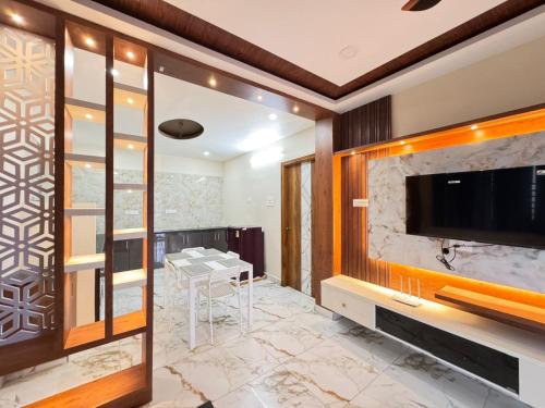 a living room with a television and a table with chairs at Urban Nest Homestay in Tirupati