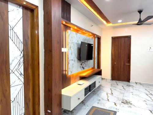 a living room with a tv on a wall at Urban Nest Homestay in Tirupati