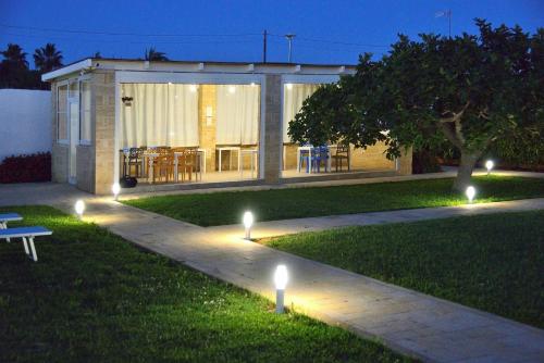 a garden with lights on the grass at night at B&B Domus Terra Mare in Torre San Giovanni Ugento