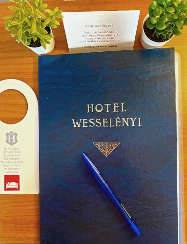 a pen sitting on top of a book on a table at Hotel Wesselényi in Győr