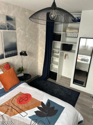 Un dormitorio con una cama y un espejo grande. en Cosy & Style blue forest room proche CDG AirPort, en Tremblay-en-France