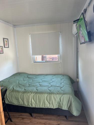 a small bedroom with a bed and a window at Apart del Este Loft 12 in Paysandú