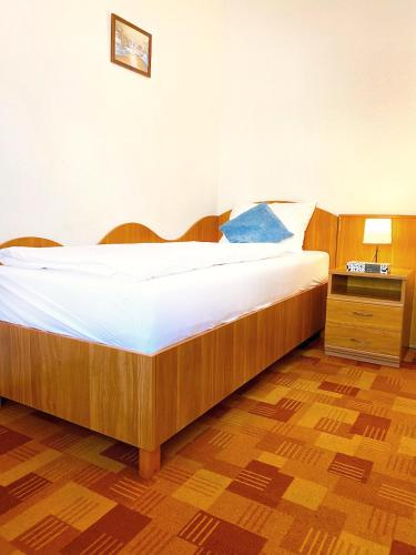 a bedroom with a large bed with a blue pillow at Hotel Wesselényi in Győr