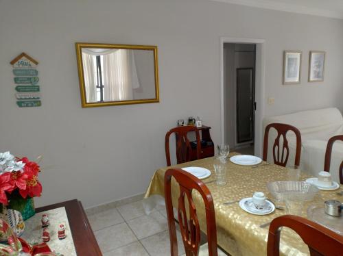 a dining room with a table and a mirror at 50 m praia pitangueiras Guarujá espaço familiar in Guarujá