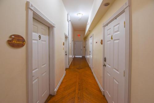 a long hallway with white doors and wood floors at VanGogh Studio in Key West