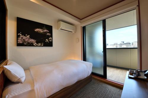 a bedroom with a bed and a large window at Wanosato Kyoto Musee in Kyoto