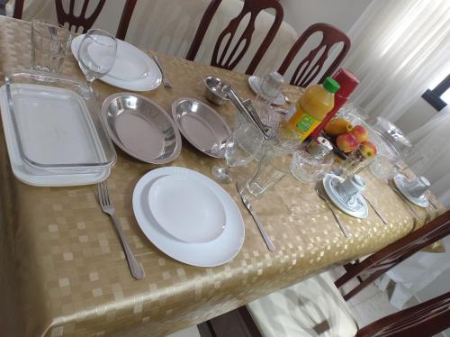 a table with white plates and utensils on it at 50 m praia pitangueiras Guarujá espaço familiar in Guarujá
