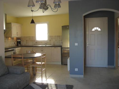 - une cuisine et une salle à manger avec une table et une porte dans l'établissement Villas de standing à Gréoux les Bains, à Gréoux-les-Bains