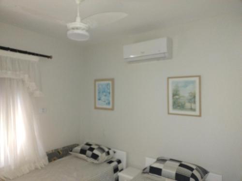 a bedroom with a bed and a window at 50 m praia pitangueiras Guarujá espaço familiar in Guarujá