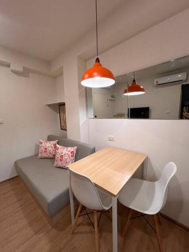 a living room with a table and a couch at Triple Cats Condo in Samutprakarn