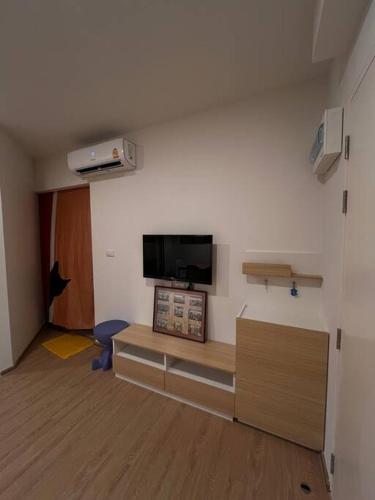 a room with a room with a tv on the wall at Triple Cats Condo in Samutprakarn