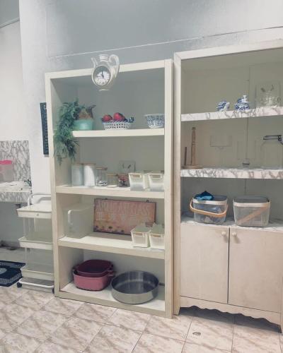 a cabinet filled with lots of dishes and bowls at Yawang homestay in Kota Bharu