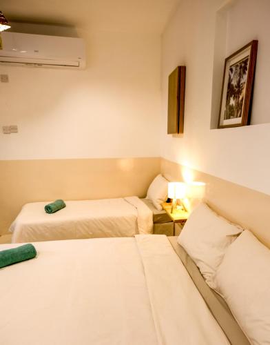 a room with two beds and a table with a lamp at Nature House in Al Ḩamrāʼ