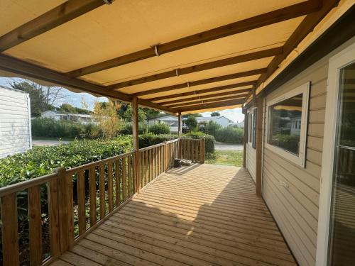 a wooden porch with awning on a house at Joli Bungalow 464 pour 4-6 pers Camping Siblu Lac des Rêves Lattes in Pérols
